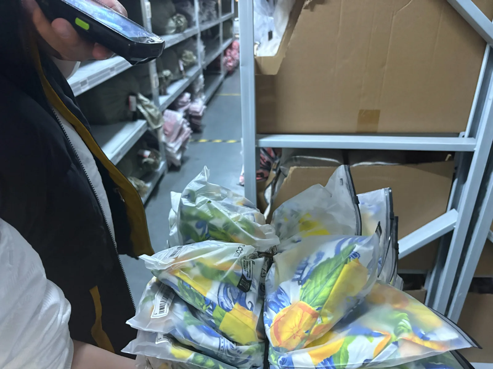 Garment factory dispatch area scanning packaged clothing orders for wholesale delivery