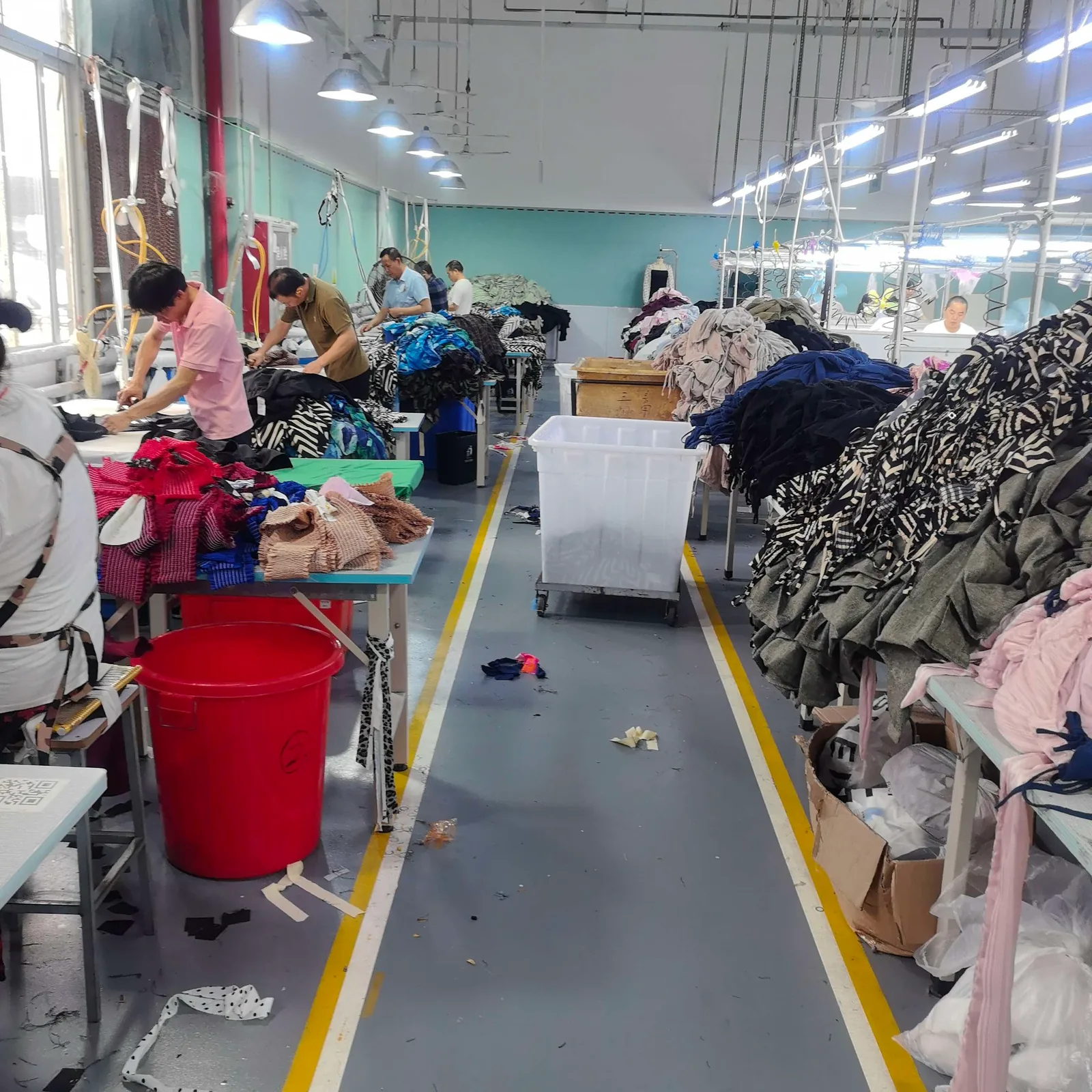 Professional garment pressing area with workers finishing custom clothing orders