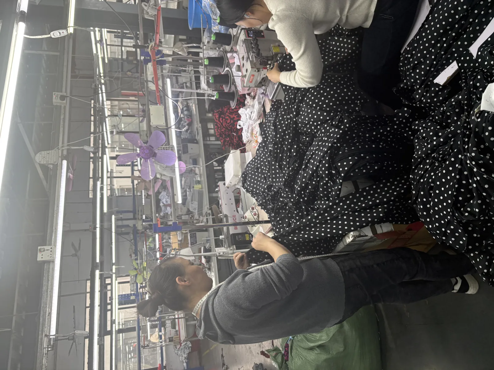 Sewing workshop with workers checking garments during custom apparel production